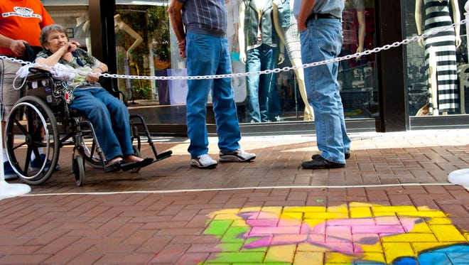 Kent Odekink and James Willcocks admire the butterfly chalk mural by Victor Navarro at Tempe Marketplace on April 12, 2014. Odekink stopped to look at the mural because it reminded him of his mother who recently passed.