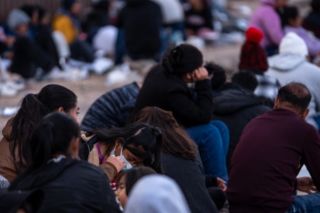 Migrants and asylum seekers wait to be picked up and processed by U.S. Border Patrol agents in Organ Pipe Cactus National Monument along the U.S.-Mexico border about a mile west of Lukeville, Ariz., on Dec. 4, 2023. The Lukeville Port of Entry was closed indefinitely by officials Dec. 4.