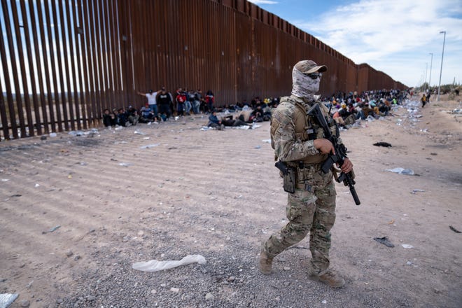 A Border Patrol Tactical Unit agent patrols an area where migrants and asylum seekers wait to be picked up and processed by U.S. Border Patrol agents in Organ Pipe Cactus National Monument along the U.S.-Mexico border about a mile west of Lukeville, Ariz., on Dec. 4, 2023. The Lukeville Port of Entry was closed indefinitely by officials Dec. 4.