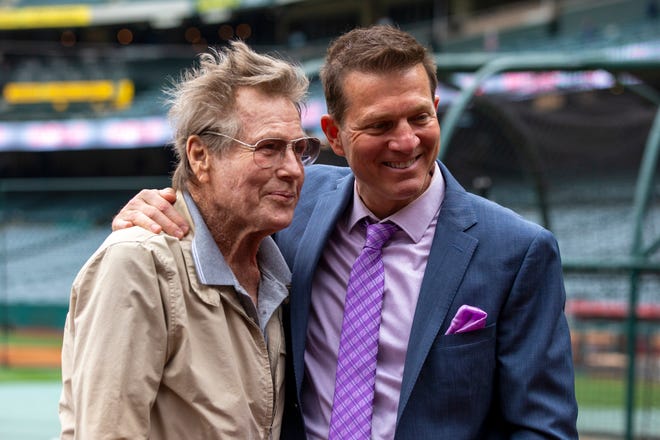 Los Angeles Angels TV play-by-play announcer Patrick O'Neal, right, poses with his father, actor Ryan O'Neal, before a baseball game against the Oakland Athletics in Anaheim, Calif., May 21, 2022.