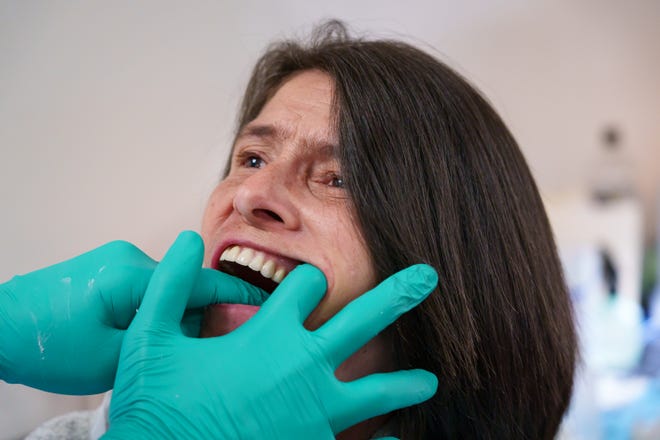 Susan Zygutis receives a new set of dentures, free of cost, at the Arizona Dental Mission of Mercy at the Veterans Memorial Coliseum at the Arizona State Fairgrounds on Dec. 8, 2023, in Phoenix.