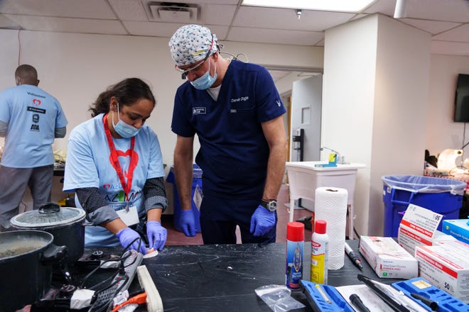 Dr. Anu Mahajan (left) and dental technician, Damir Zega mold a set of dentures for a patient at the Arizona Dental Mission of Mercy at the Veterans Memorial Coliseum at the Arizona State Fairgrounds on Dec. 8, 2023, in Phoenix.
