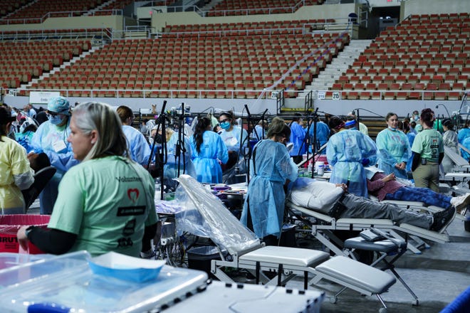Patients receive cleanings and dental hygiene care at the Arizona Dental Mission of Mercy at the Veterans Memorial Coliseum on Dec. 8, 2023, in Phoenix. Cleanings, among other services, are provided free of charge at this annual event.